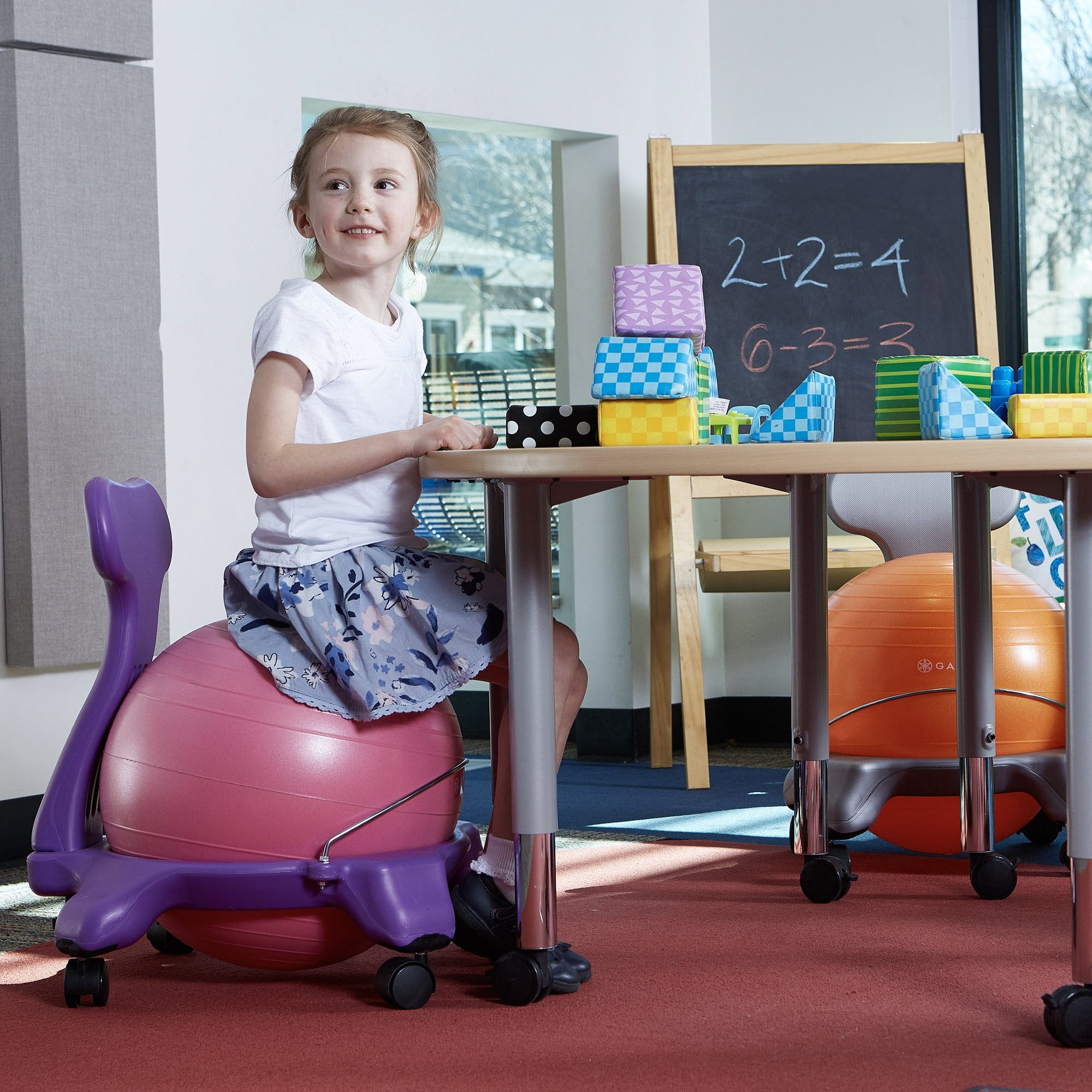 Sitting on the Pink/Purple Kids Classic Balance Ball Chair